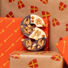 Triple Chocolate letter S with nuts, surrounded by Sinterklaas presents